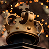 Picture of Columbia Crown above the Morningside gate entrance, illuminated by holiday lights in the background.