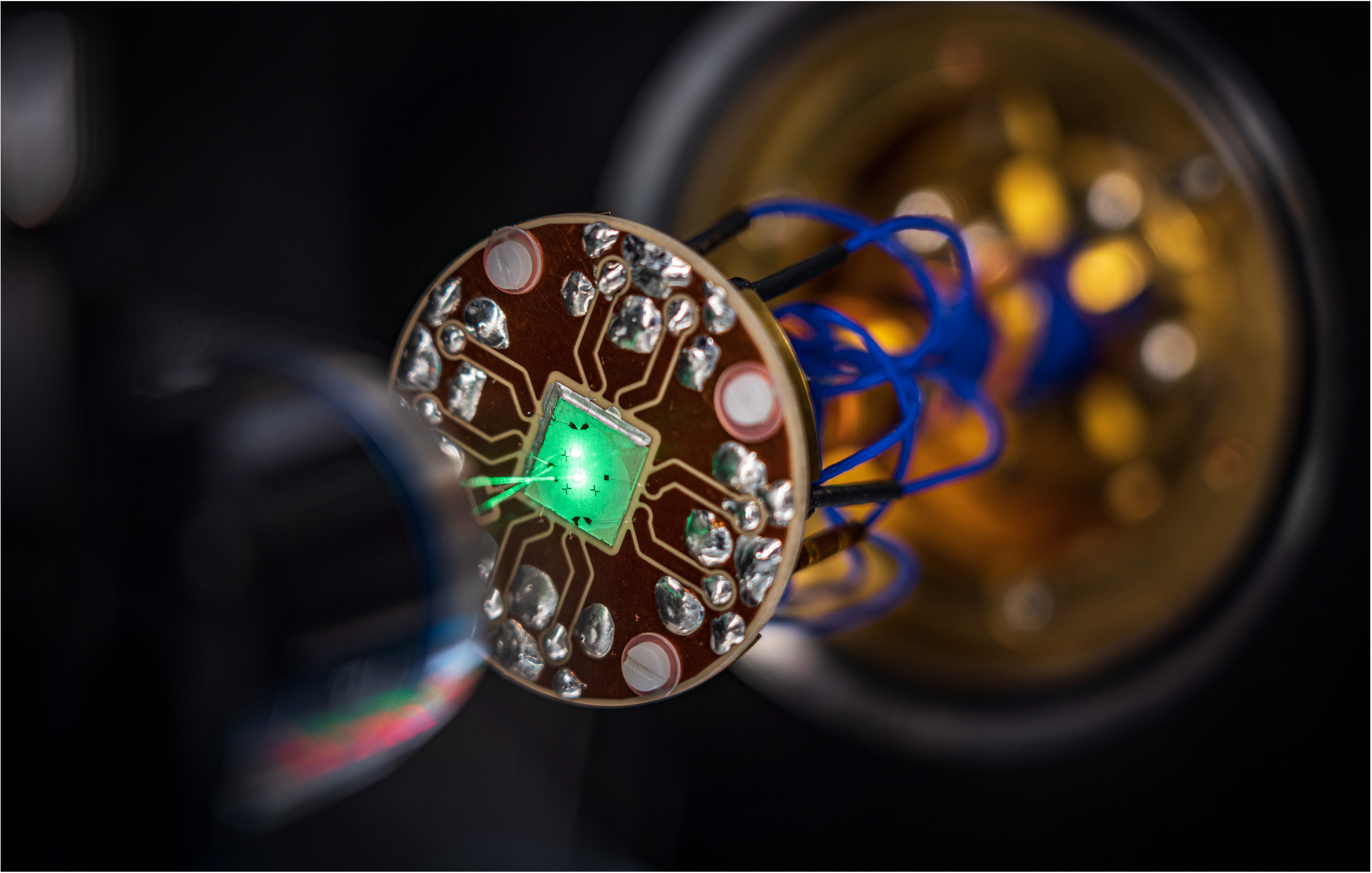 An on-chip device studied in the McIver Lab, where laser light is focused through a microscope to probe and control the material’s electronic behavior.